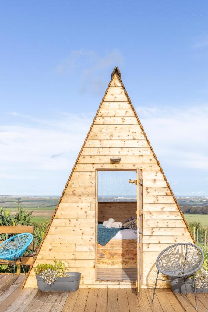 Maison triangulaire avec 2 chaises et une fenêtre dans l'établissement Nuit insolite à la campagne, à Fiennes