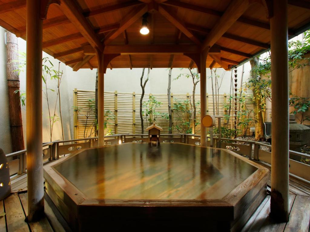 - un bain à remous au milieu d'une pièce ornée de plantes dans l'établissement Hatori, à Kaga