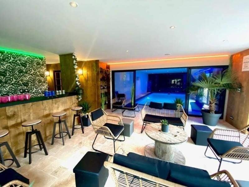 - un hall doté d'un bar avec des chaises et des tables dans l'établissement Chalet avec accès piscine illimité, à Fiennes