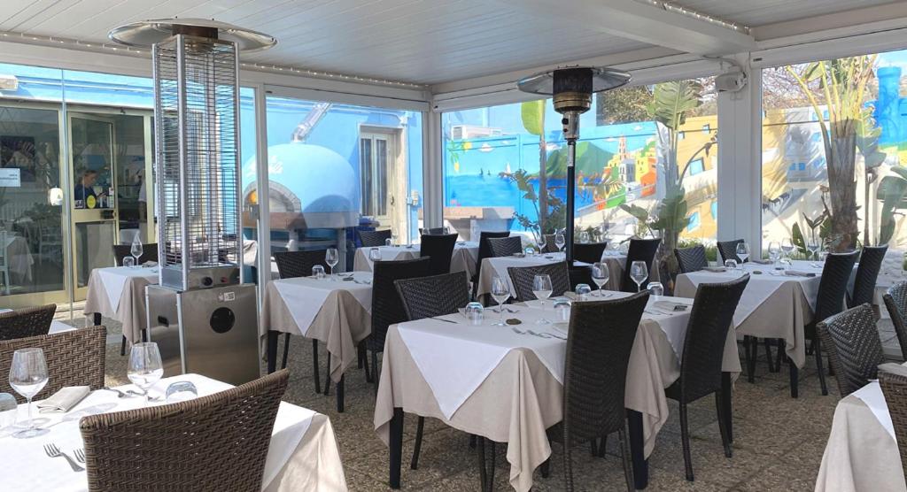 un restaurant avec des tables et des chaises avec une nappe blanche dans l'établissement Hotel Piccolo Paradiso, à Bordighera