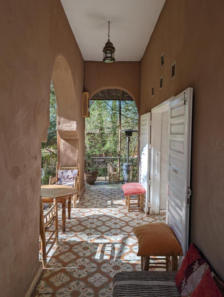 Cette chambre dispose d'un couloir avec une table et des chaises. dans l'établissement Villa Zagora Ma Villa au Sahara, à Zagora