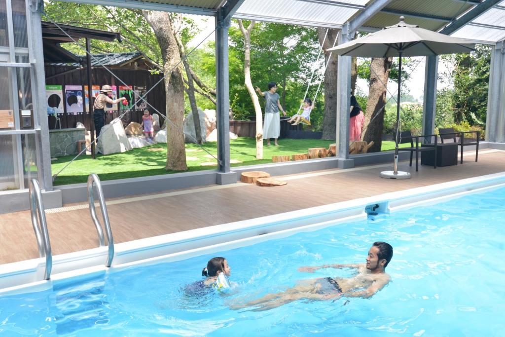 un homme et une femme nageant dans une piscine dans l'établissement Arima Onsen Motoyu Ryuusenkaku, à Kobe