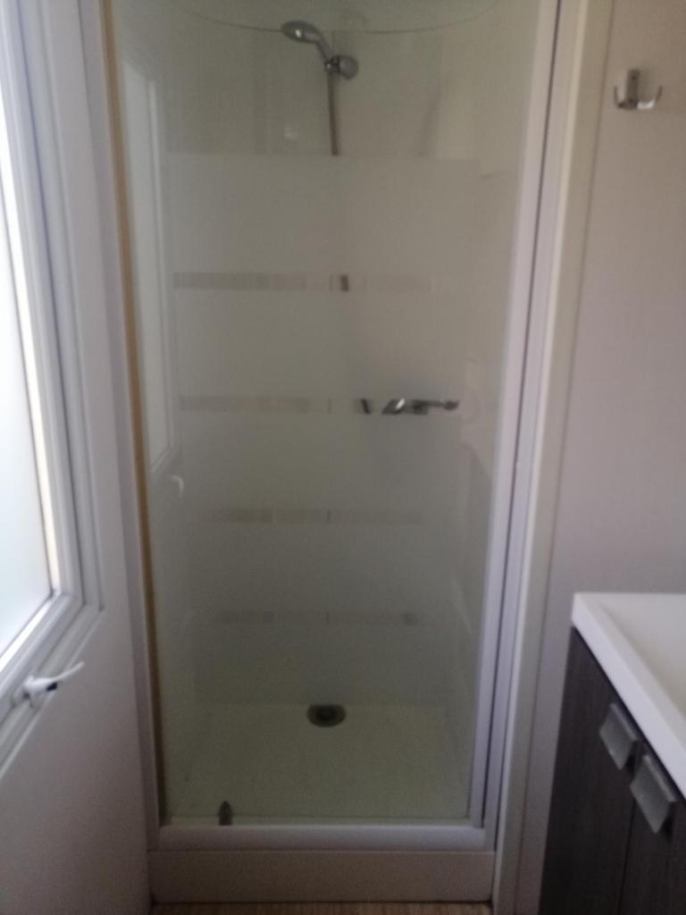 une douche avec une porte vitrée à côté d'un lavabo dans l'établissement Mobil home chez Alain120, à La Roque-dʼAnthéron