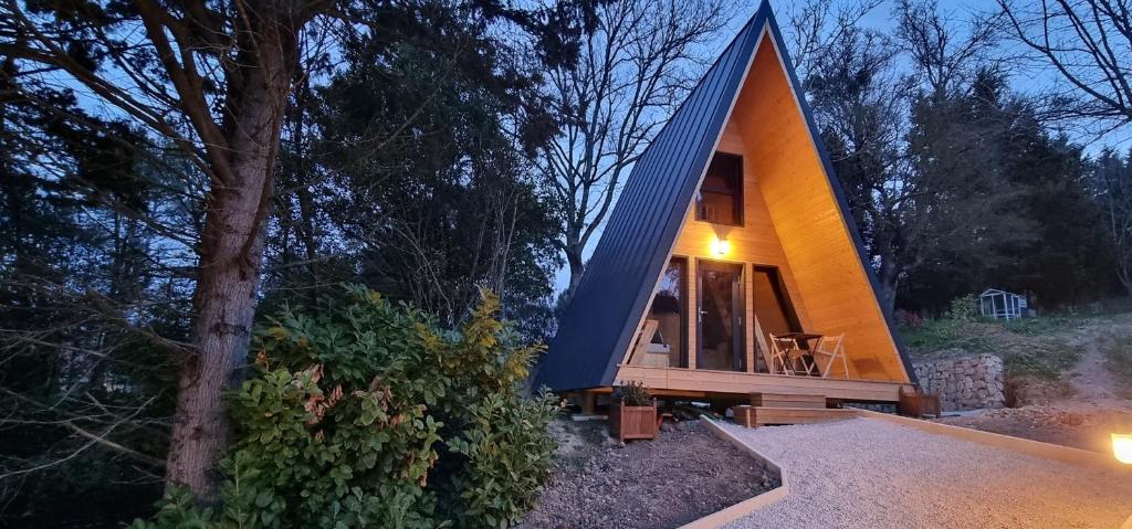 une petite maison avec un toit en pointeau dans les bois dans l'établissement Le tipi Cathare hébergement insolite Carcassonne, à Alairac