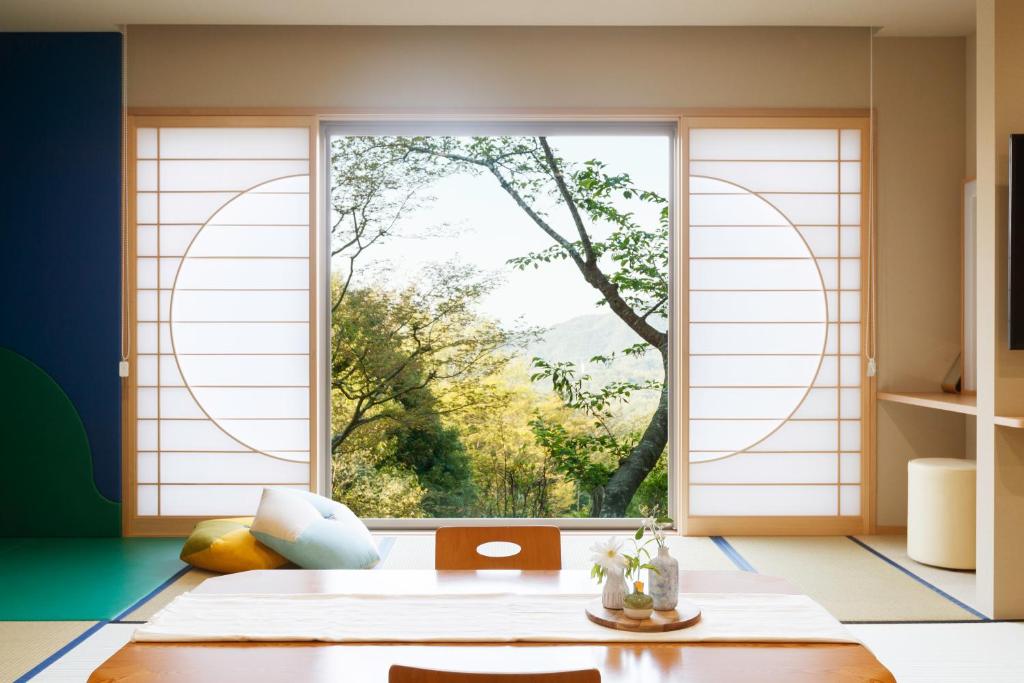 Cette chambre dispose d'une fenêtre offrant une vue sur un arbre. dans l'établissement Arima Onsen Motoyu Ryuusenkaku, à Kobe