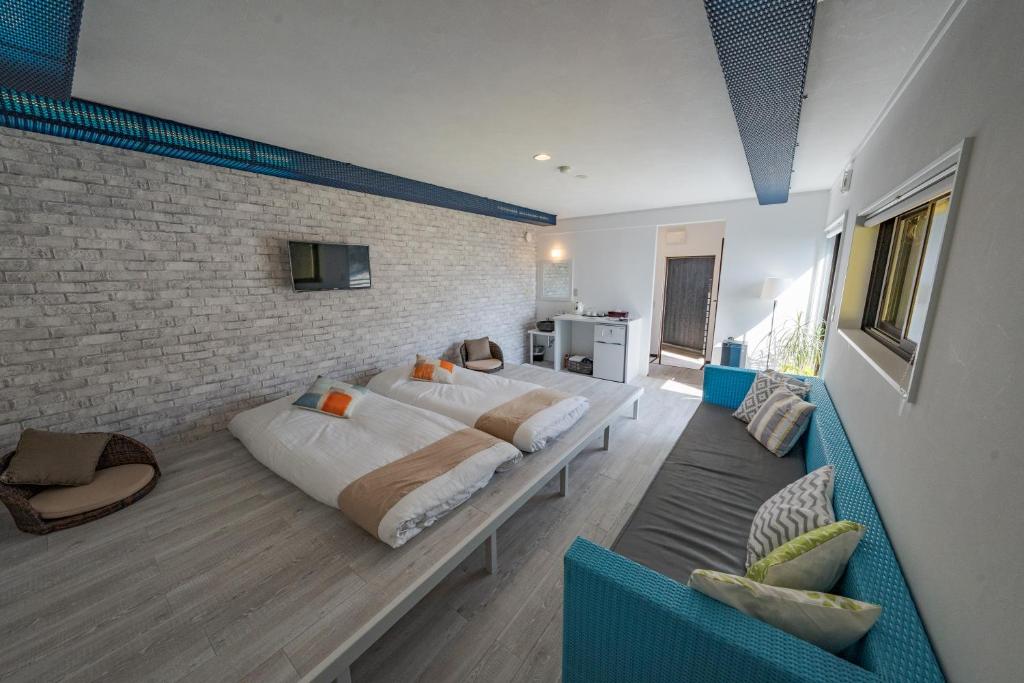 une chambre avec un grand lit et un mur de briques dans l'établissement XYZ Private Spa and Seaside Resort, à Shirahama
