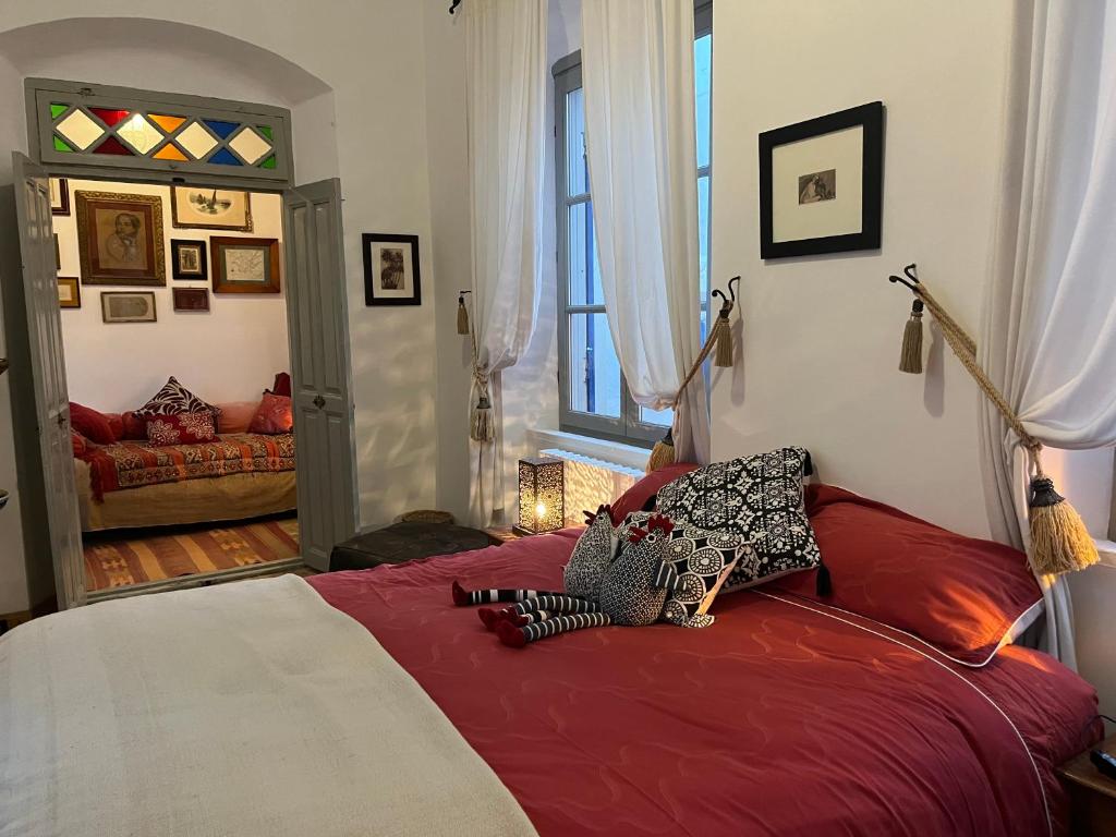 - une chambre avec un grand lit et des draps rouges dans l'établissement Riad le Consulat - Private Riad, Breakfast included, à Essaouira