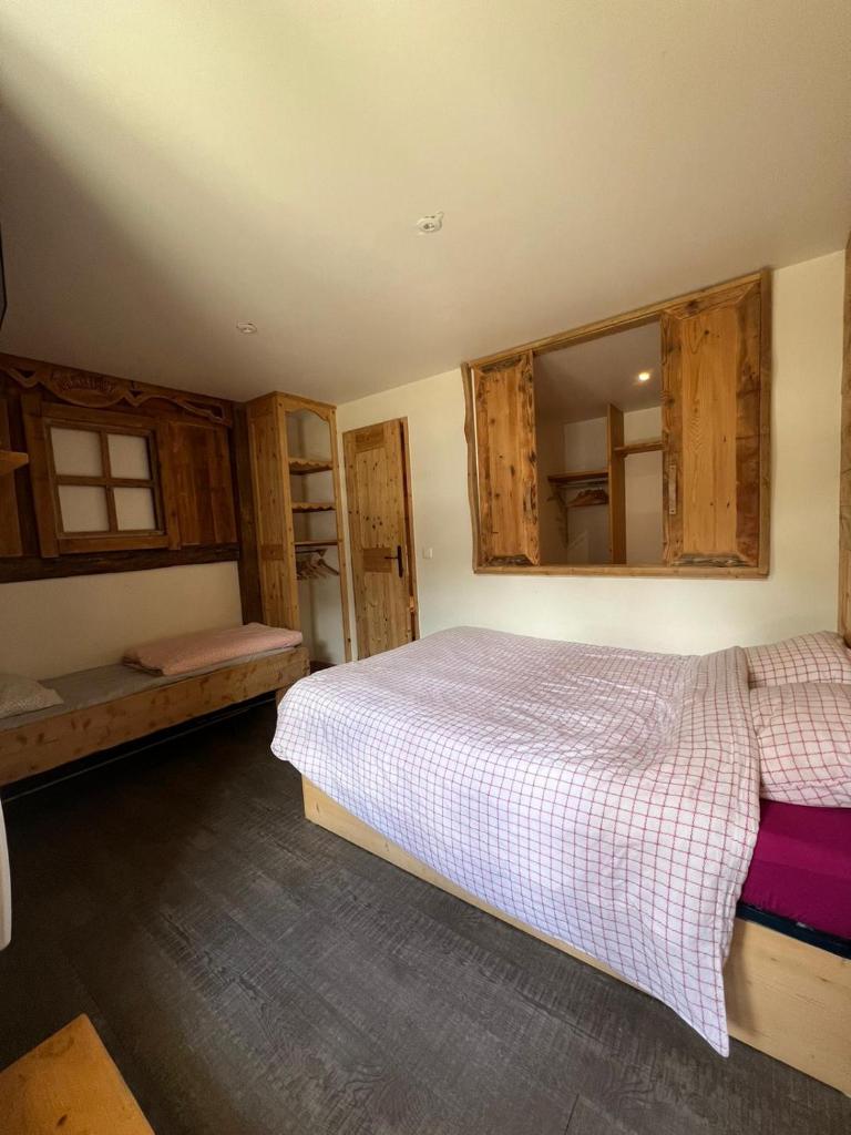 - une chambre avec un lit et quelques placards en bois dans l'établissement Meribel 17, à Méribel 5 autres photos