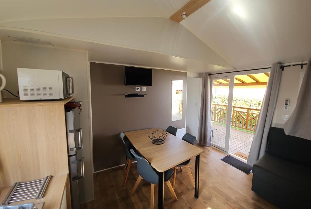 une petite chambre avec une table et une cuisine avec un balcon dans l'établissement Les bords du Rhône, à Condrieu