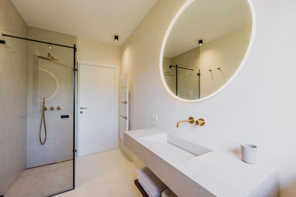 une salle de bain avec un lavabo et un miroir dans l'établissement Artylino, à Lazise