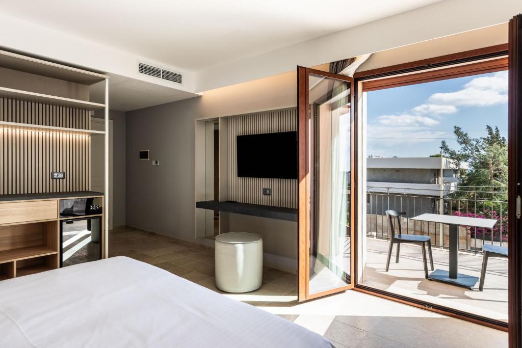 Cette chambre dispose d'un balcon avec un lit et une télévision. dans l'établissement Hotel Netum Mare, à Noto Marina