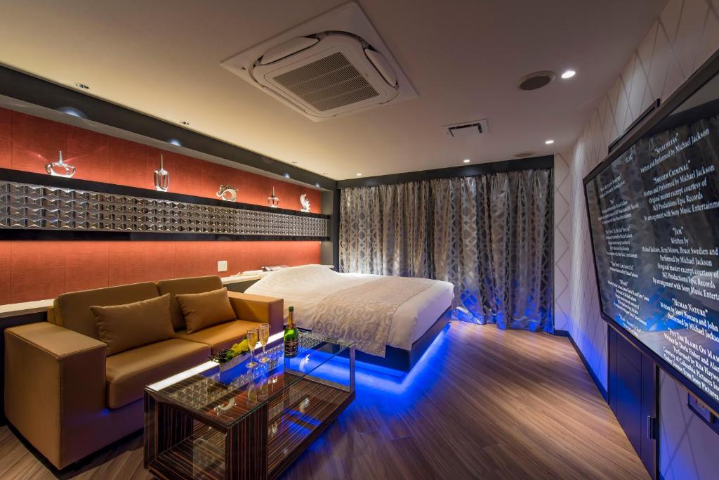 une chambre d'hôtel avec un lit et un canapé dans l'établissement HOTEL COSTA RESORT Omiya, à Saitama