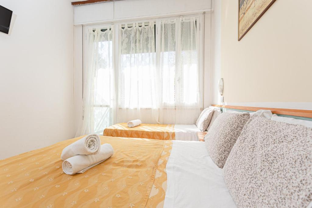 une chambre avec deux lits et une fenêtre dans l'établissement Hotel Gadames - Lunch on the Beach, à Cervia
