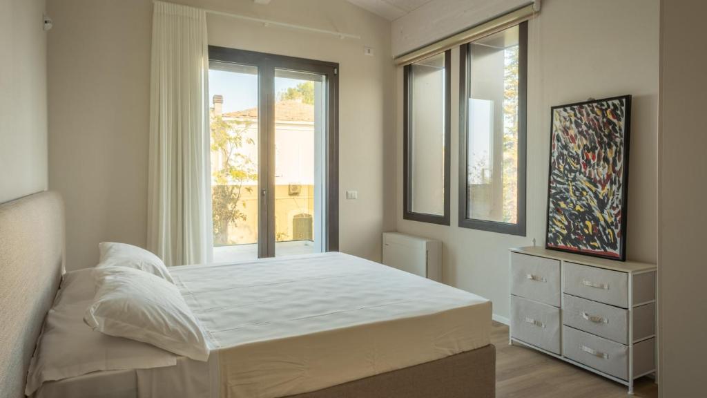 une chambre avec un lit et une grande fenêtre dans l'établissement ONDA 8, Emma Villas, à Santa Maria di Scacciano
