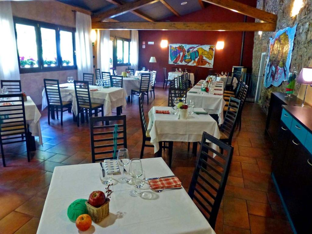 une salle à manger avec des tables et des chaises blanches dans un restaurant dans l'établissement Villa Le Panche, à Pontepetri