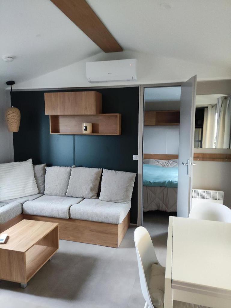 - un salon avec un canapé et une chambre dans l'établissement Mobil-home dans camping 4 étoiles 6 à 8 personnes 40m2, à Lège-Cap-Ferret
