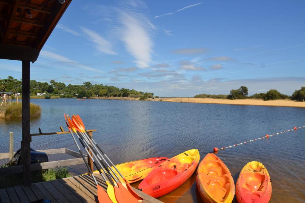 un groupe de kayaks attachés à un quai sur un lac dans l'établissement Mobil-home dans camping 4 étoiles 6 à 8 personnes 40m2, à Lège-Cap-Ferret