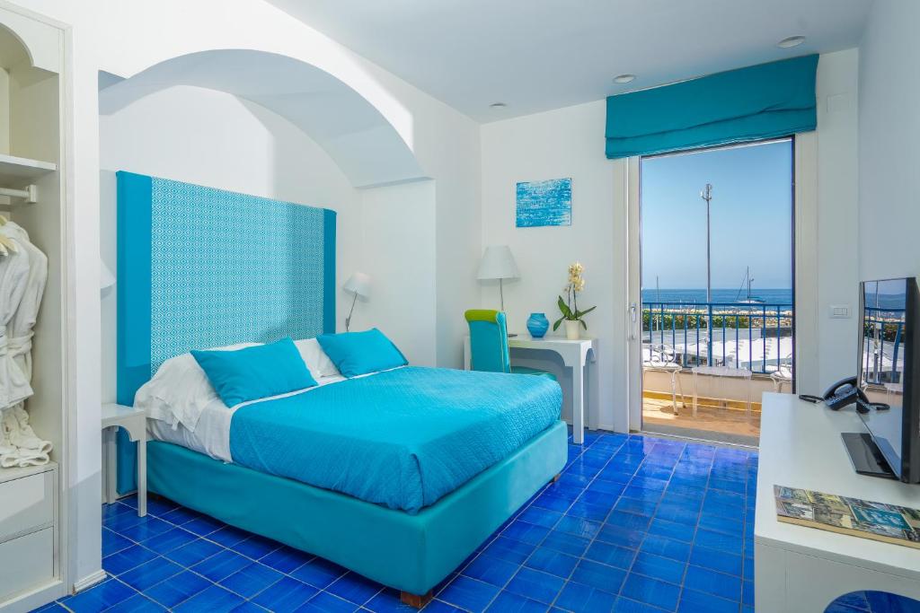une chambre avec un lit bleu et un balcon dans l'établissement Le Ancore Hotel, à Vico Equense 60 autres photos