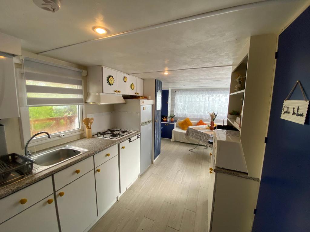 une cuisine avec des armoires blanches et un évier dans l'établissement Mobil home confortable Gorges du Verdon, à Sainte-Croix-de-Verdon