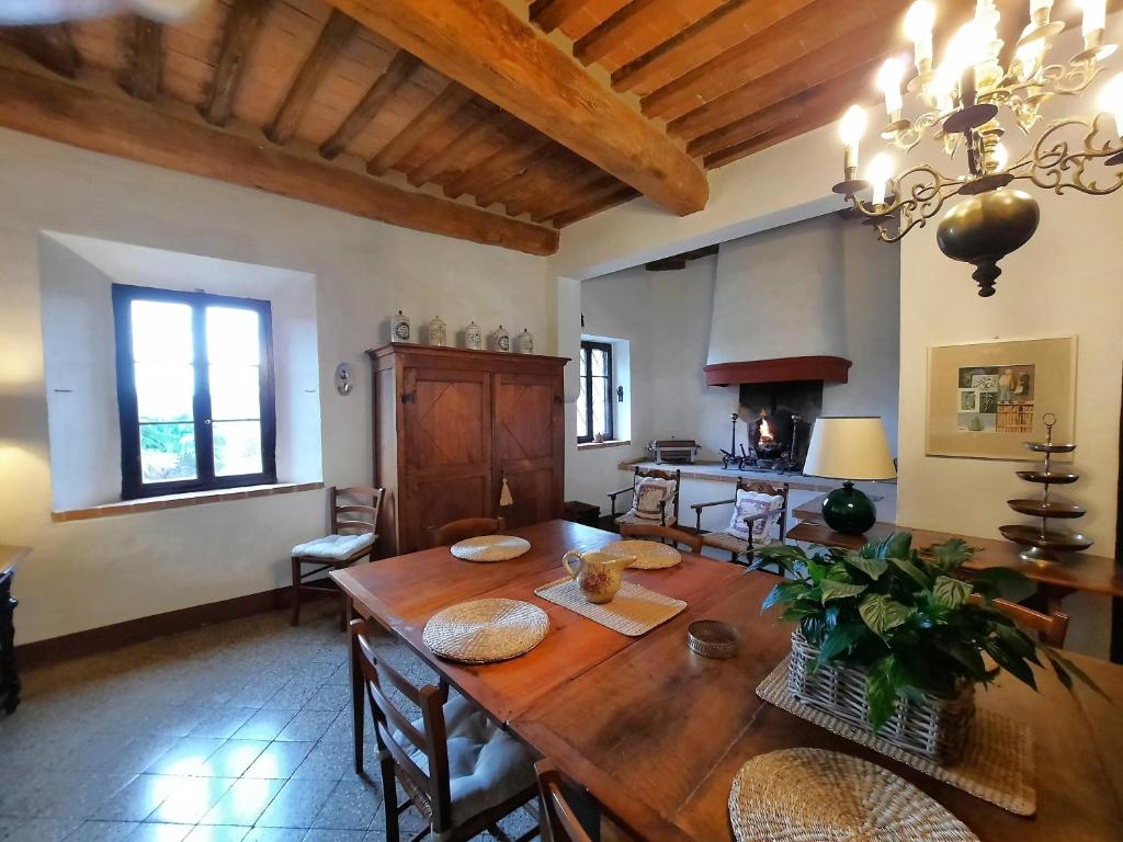 d'une salle à manger avec une table en bois et des chaises. dans l'établissement Pasqui Villas La Consuma villa storica in paese con vista pscina WiFi, à San Giovanni dʼAsso