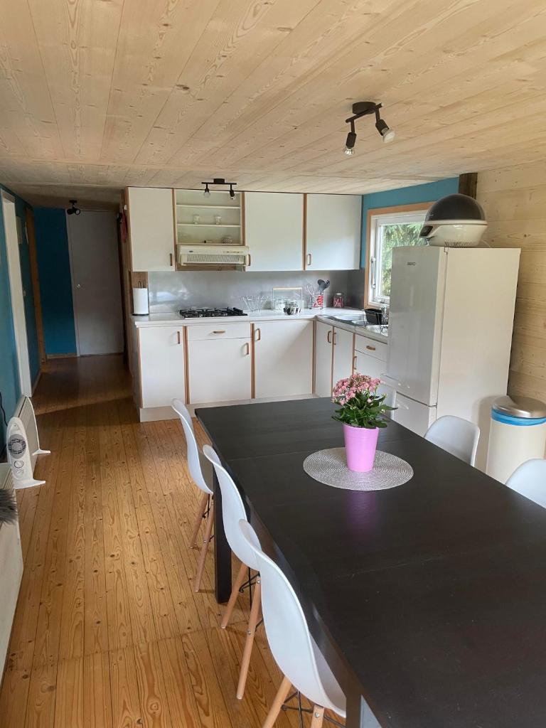 une cuisine avec une table noire et des appareils électroménagers blancs dans l'établissement Chalet 9 personnes, piscine, terrasse, à Saint-Maurice-sur-Moselle 5 autres photos