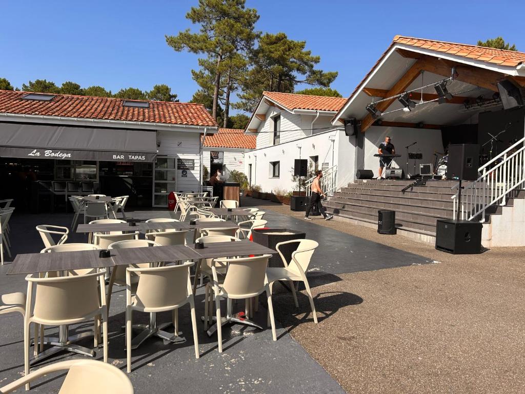 une rangée de tables et de chaises devant un bâtiment dans l'établissement Notre bulle du ferret, à Lège-Cap-Ferret