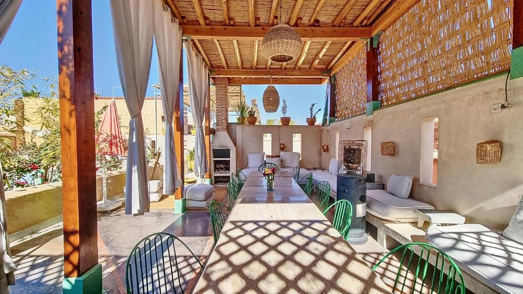 une terrasse avec des chaises vertes et une table dans l'établissement Riad Chambres D'Amis Marrakech, à Marrakech