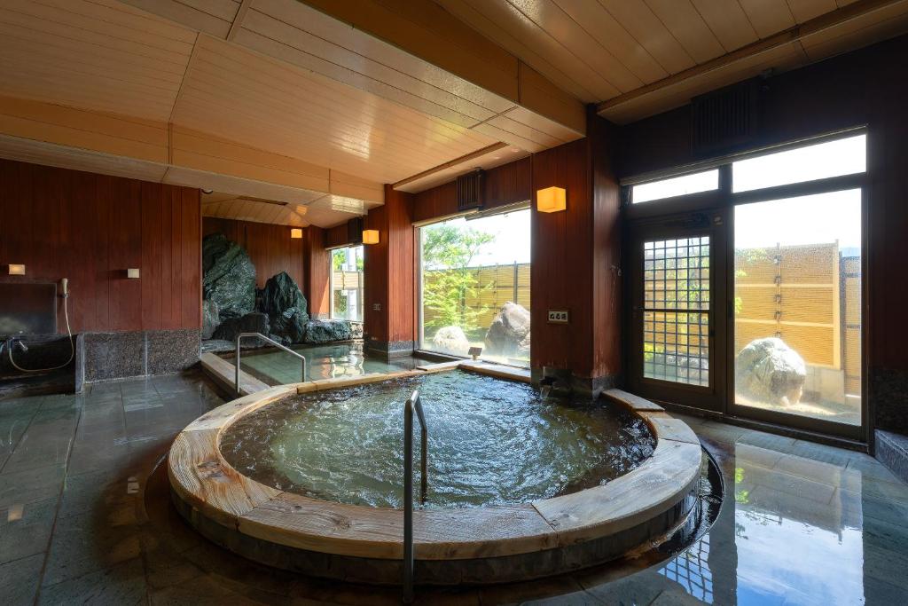 une chambre avec une grande piscine d'eau dans un bâtiment dans l'établissement Roppokan, à Asakura