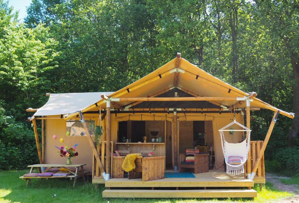 d'un kiosque avec terrasse couverte sur gazon. dans l'établissement Camping Le Pech Charmant, à Les Eyzies-de-Tayac
