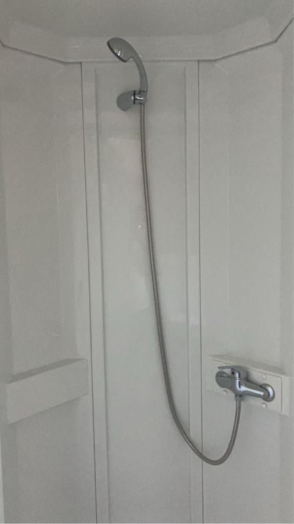 une douche avec pommeau de douche dans une salle de bain dans l'établissement Mobil-home Camping - La Marine - Grau du Roi, au Grau-du-Roi 14 autres photos