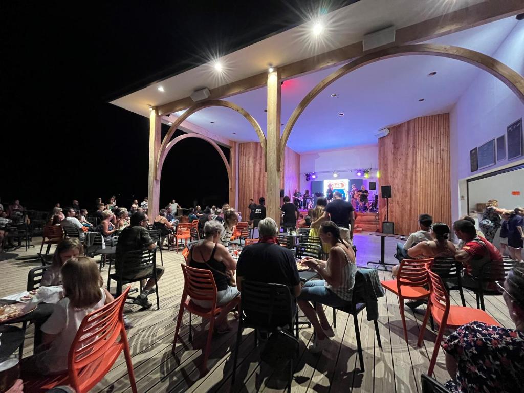 Une foule de personnes assises à des tables dans une pièce dans l'établissement Camping Campilo - Maeva, à Aubigny