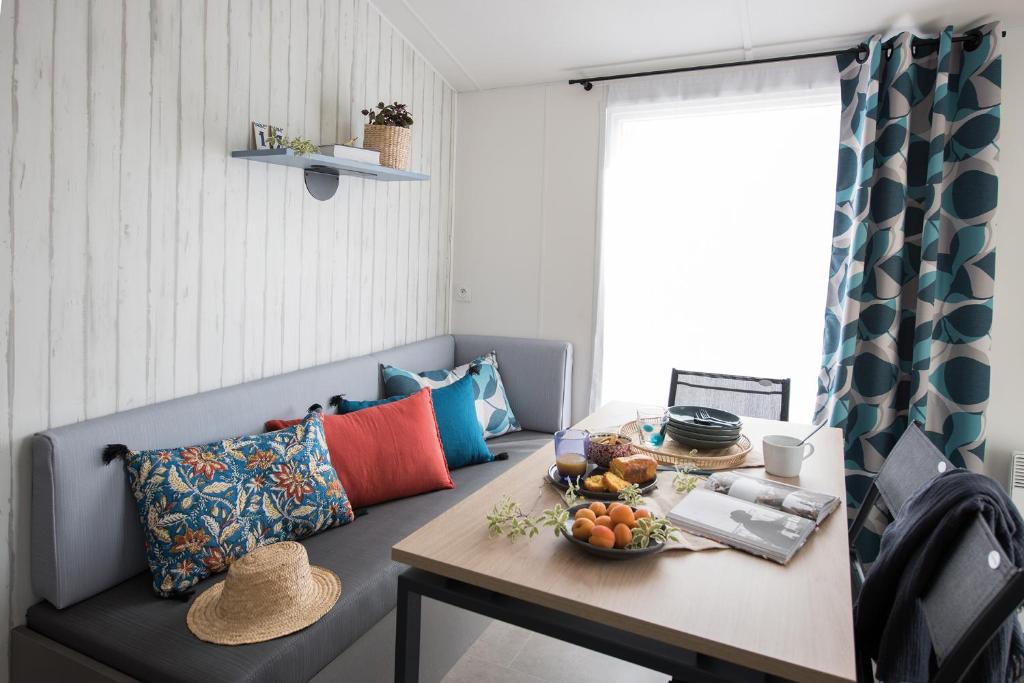 Cette chambre comprend une table avec un bol de fruits. dans l'établissement Camping Le Panoramic - Maeva, à Binic