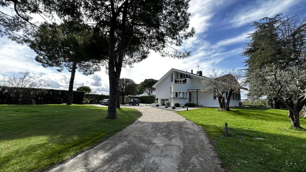 une allée menant à une maison blanche dans l'établissement Villa Pronti Santarcangelo - Rimini, à Santarcangelo di Romagna