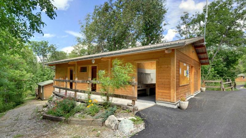 Cette petite cabane en bois dispose d'une grande fenêtre. dans l'établissement Camping Les Airelles - Maeva, à Baratier