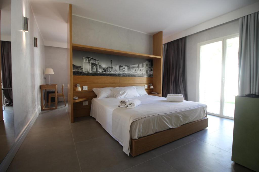 une chambre avec un grand lit et une grande fenêtre dans l'établissement Hotel Lo Scoglio, à Porto Cesareo