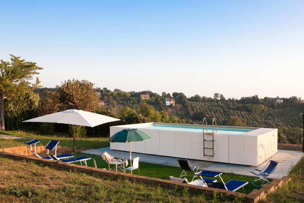 - une piscine avec des chaises et des parasols à côté dans l'établissement Villa Dell'Arco - Sea View, Private Pool & AirCo, à SantʼElpidio a Mare