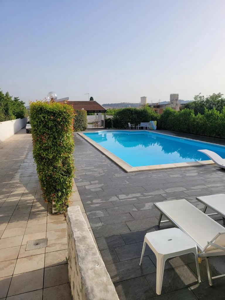 - une piscine avec une table et des chaises sur la terrasse dans l'établissement Villa Giacomo con piscina, à Santa Maria Del Focallo