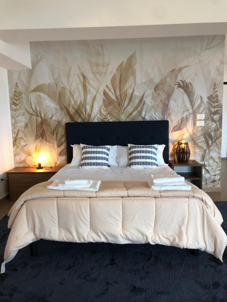 une chambre avec un grand lit avec un papier peint fleuri dans l'établissement Thalassa Suite & Spa, à Reggio de Calabre