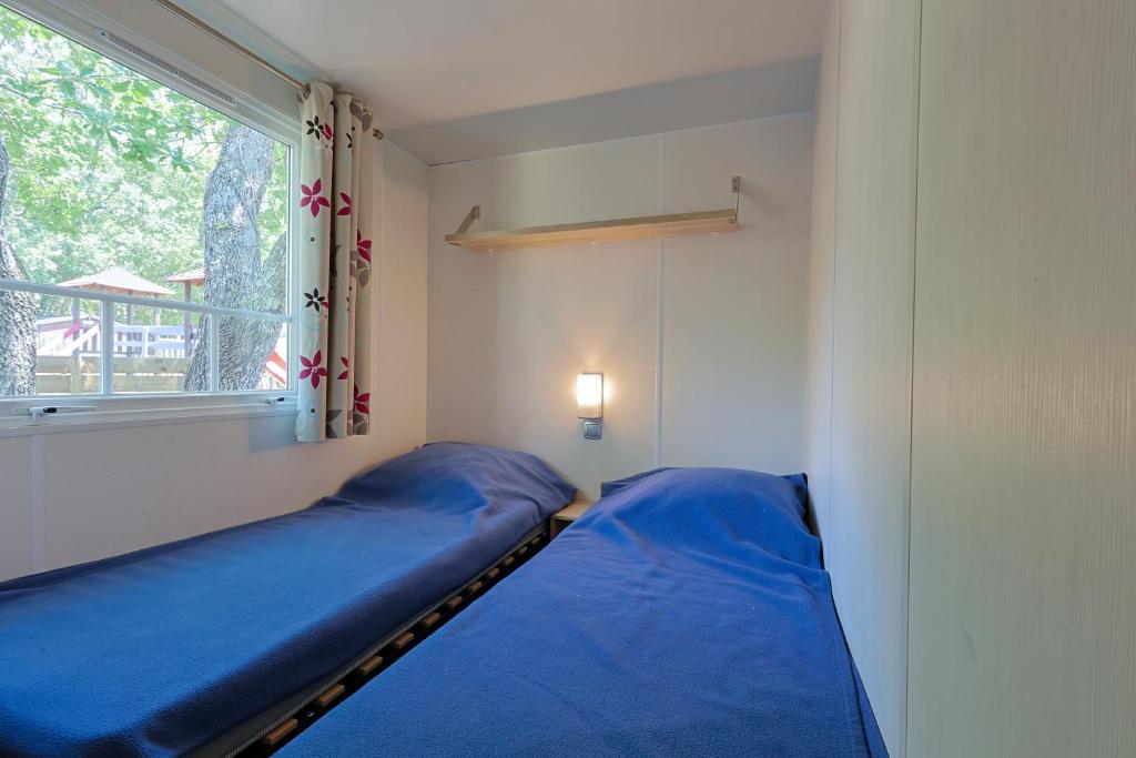 un lit dans une chambre avec une fenêtre dans l'établissement Camping Domaine Villa Verde, à Callas