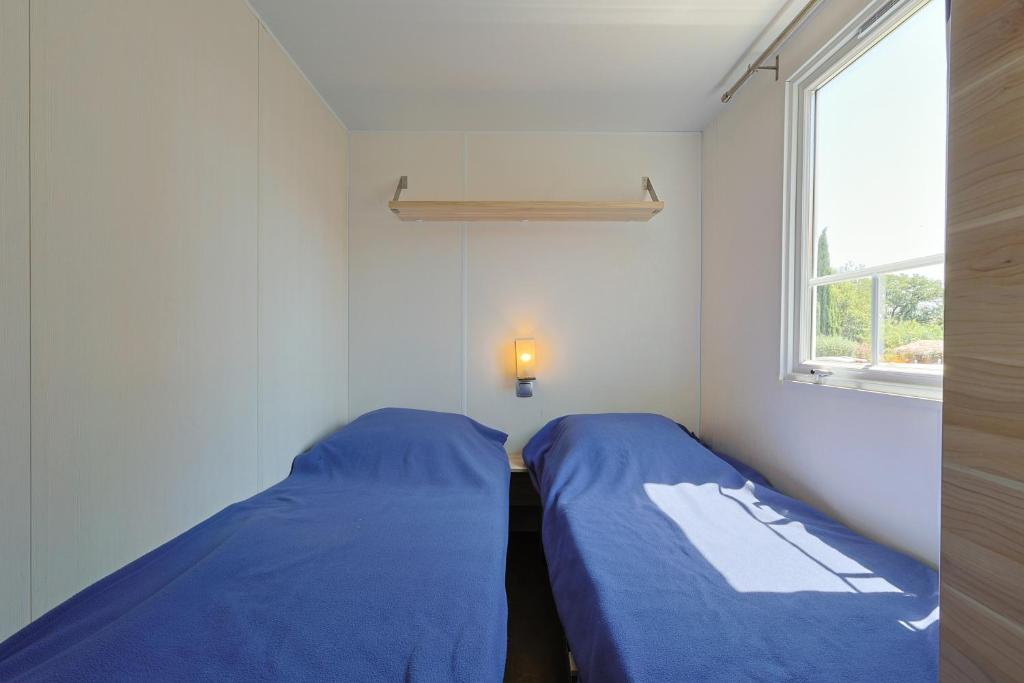 deux lits dans une petite pièce avec une fenêtre dans l'établissement Camping Domaine Villa Verde, à Callas 37 autres photos