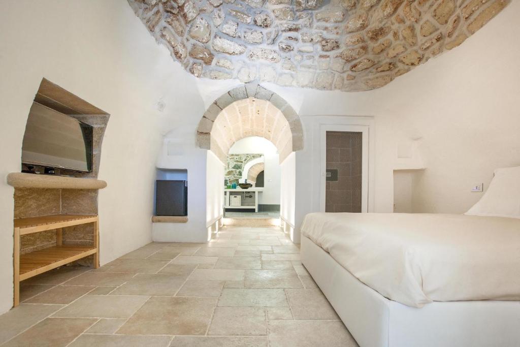 une chambre avec un lit blanc et un canapé dans l'établissement Muse Salentine, à Santa Maria al Bagno