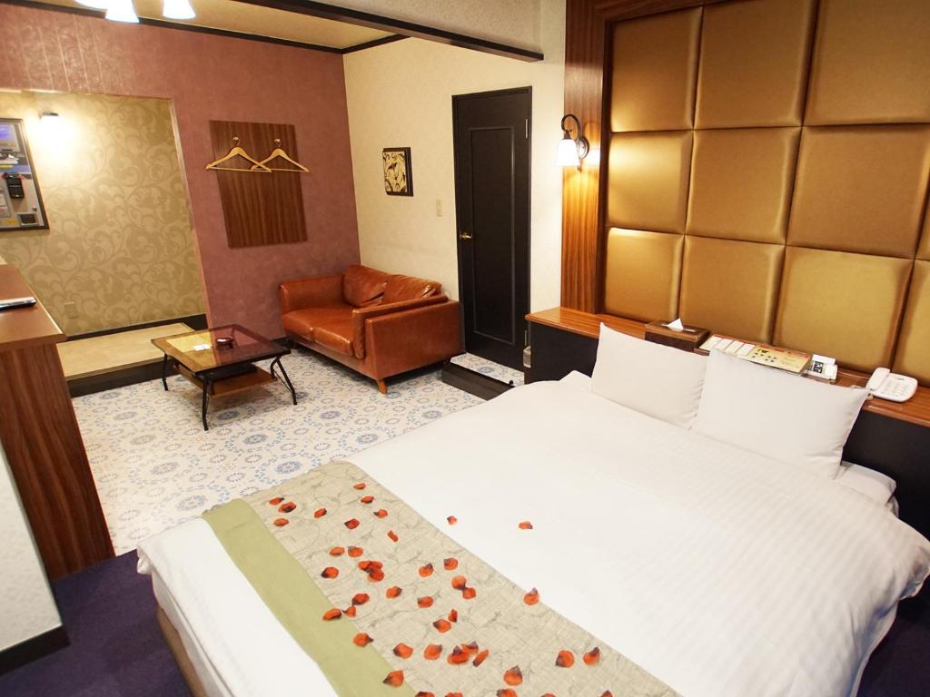 une chambre d'hôtel avec un lit et une chaise dans l'établissement Hotel FirstWood 成田店, à Narita