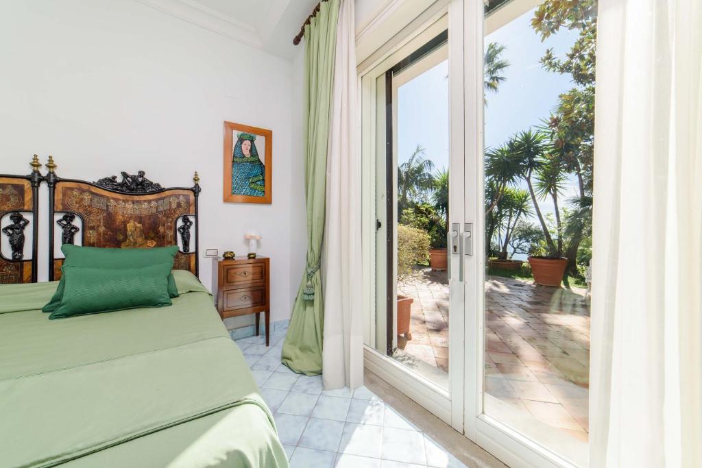 une chambre avec un lit et une porte coulissante en verre dans l'établissement Starhost - Villa il Poggio Amalfi Coast with pool, garden and terrace, à Vietri 194 autres photos