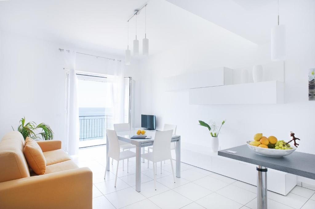 un salon blanc avec une table et un canapé dans l'établissement Vuelle Residence Apartments, à Capo dʼOrlando