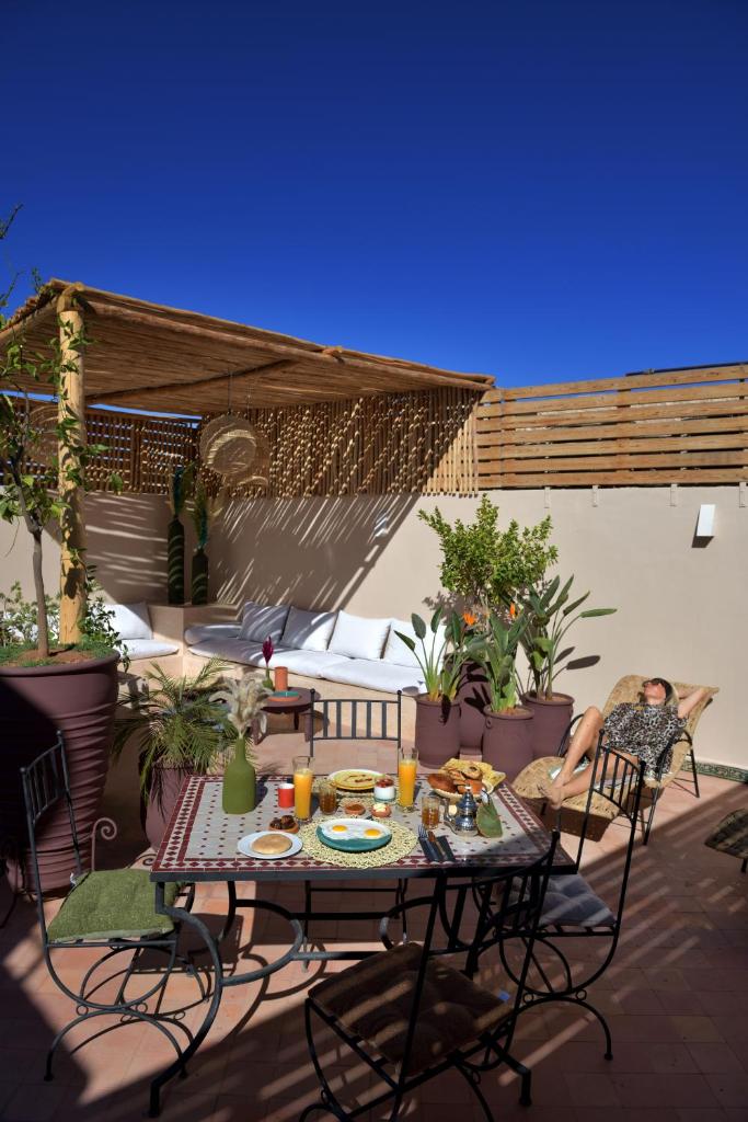 un patio avec une table, des chaises et des plantes dans l'établissement Riad Palau Marrakech, à Marrakech