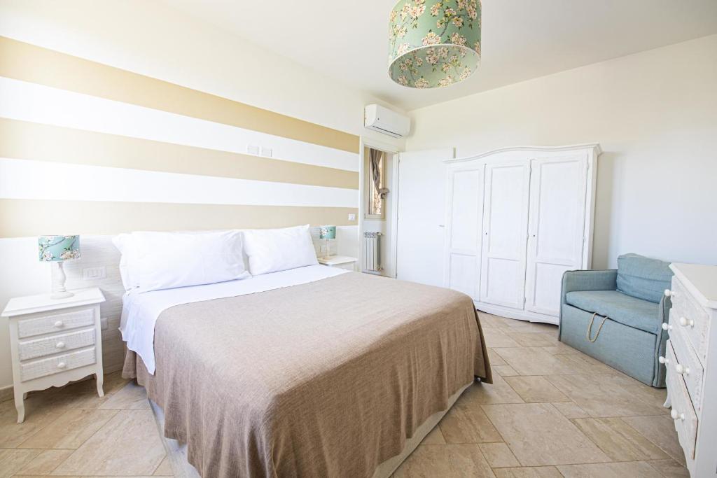 une chambre avec un lit et une chaise bleue dans l'établissement Villa Elisabetta con idromassaggio e area piscina, à Gallipoli 42 autres photos