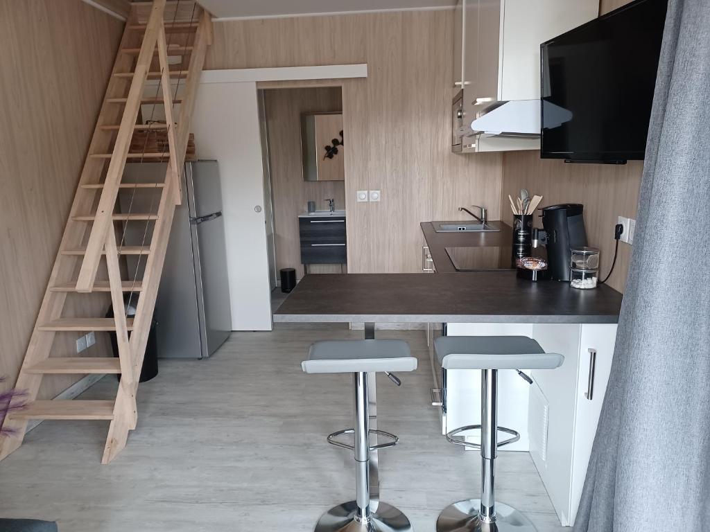 une cuisine avec un comptoir et des tabourets dans une pièce dans l'établissement La Cabanne du Vigné, à Saint-Pargoire