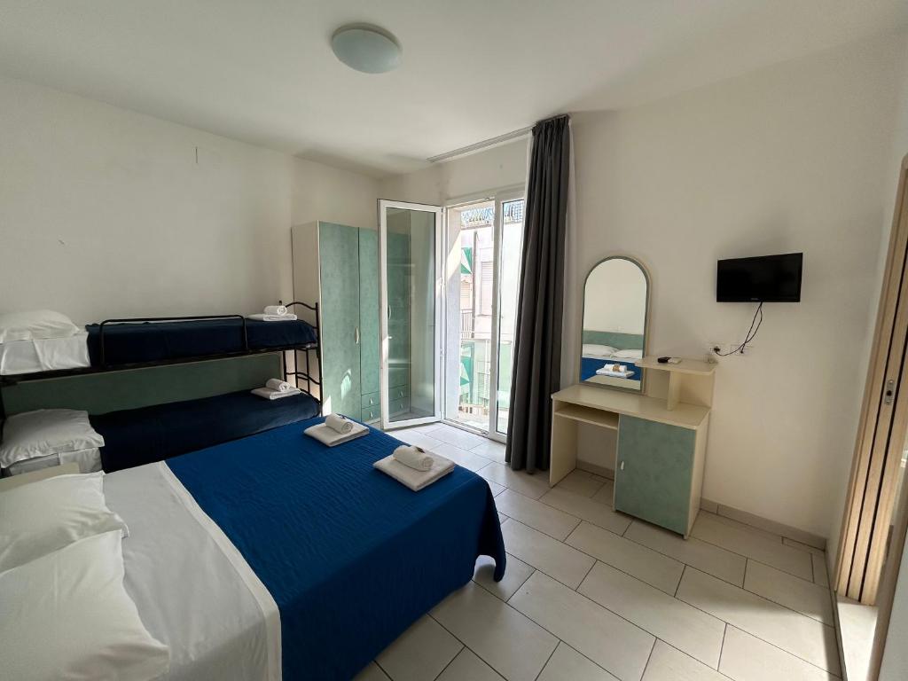 une chambre avec un lit bleu et une fenêtre dans l'établissement Hotel Zamagna, à Cesenatico