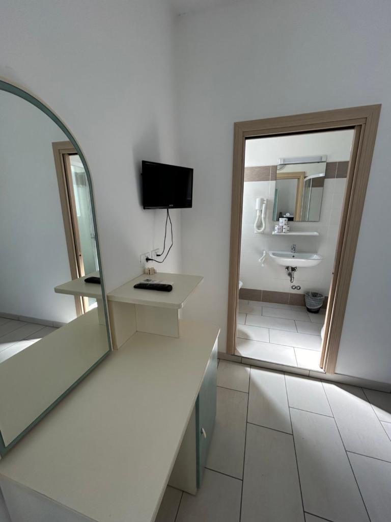 une salle de bain blanche avec un lavabo et un miroir dans l'établissement Hotel Zamagna, à Cesenatico 93 autres photos