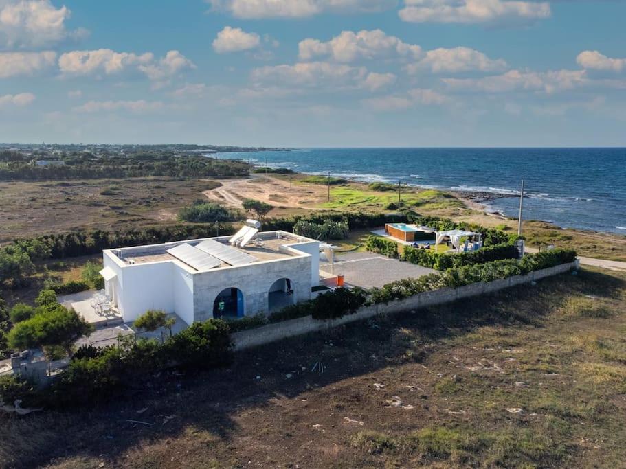 - une vue aérienne sur une petite maison blanche à côté de l'océan dans l'établissement Hemingway Villa-refurbished 2025, à Specchiolla